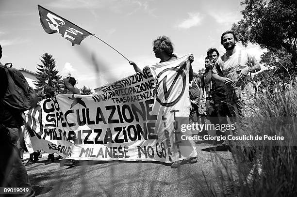 Demonstrators holding politcal banners walk on a road towards L'Aquila during a protest against the G8 summit on the third day of the international...
