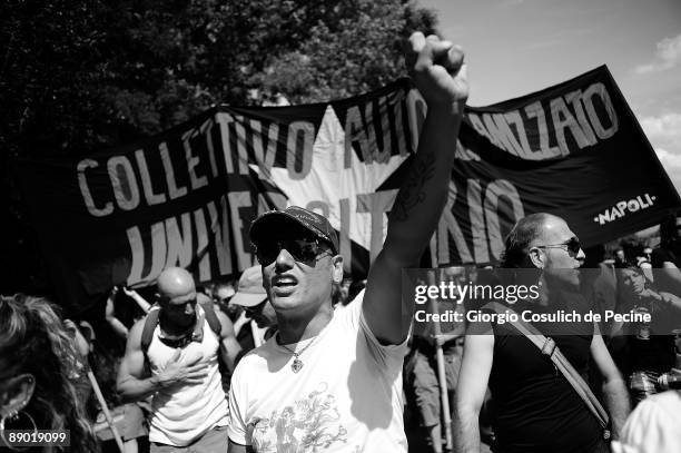 Demonstrators shouting political slogans walk on a road towards L'Aquila during a protest against the G8 summit on the third day of the international...