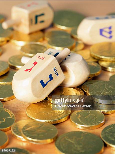 jewish dreidels on gold chocolate coins - ハヌカゲルト ストックフォトと画像