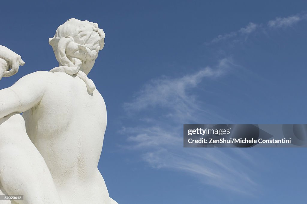 Sculpture looking toward blue sky, rear view