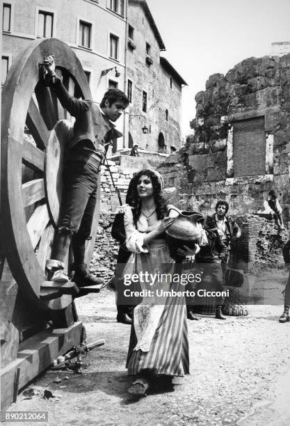 Adriano Celentano acting at the 'Marcello theater' for the musical comedy 'Rugantino', he is tied to a big wheel and Claudia Mori is near him holding...