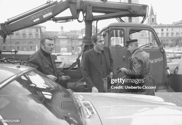 Adriano Celentano with the traffic policemen while they take away the car parked in a no parking area, Rome 1976. Adriano Celentano is a famous...