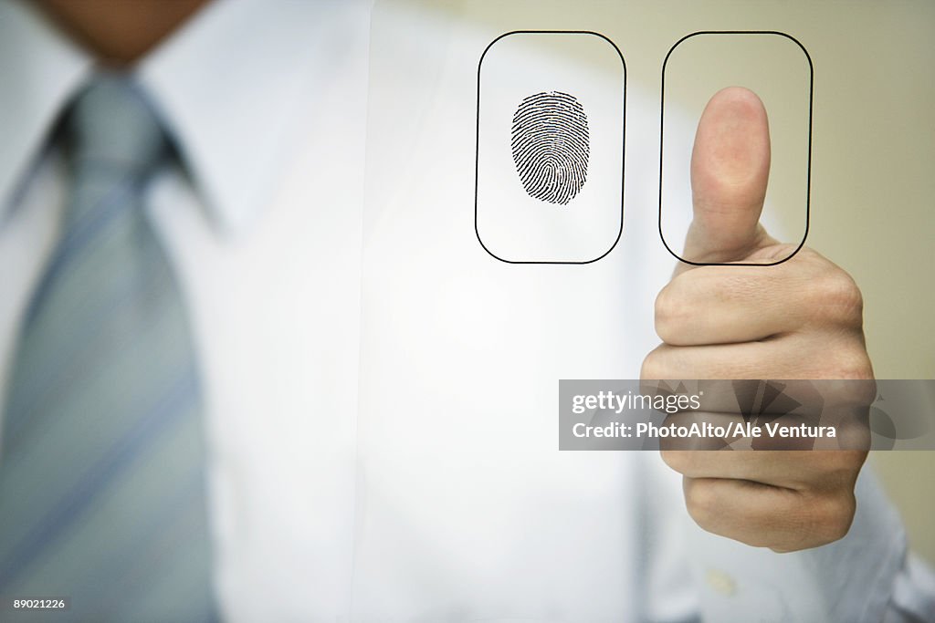 Man pressing thumb to fingerprint reader