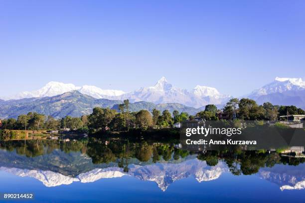 lake phewa in pokhara, nepal, with the himalayan mountains in the background, including machhapuchare and annapurna - machapuchare stock pictures, royalty-free photos & images