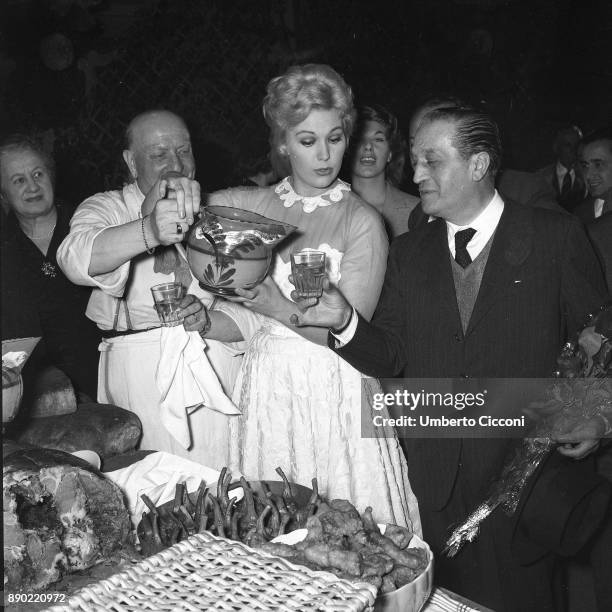 American film actress Kim Novak enjoys a picnic and pours the water to film producer Sandro Pallavicini at Cinecittà Studios, Rome 1956.