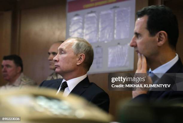 Russian President Vladimir Putin and his Syrian counterpart Bashar al-Assad attend a meeting with Russian military officers during their visit to the...