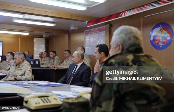 Russian President Vladimir Putin , his Syrian counterpart Bashar al-Assad , and Russian Defence Minister Sergei Shoigu attend a meeting with Russian...