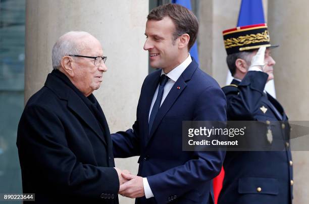 French President Emmanuel Macron welcomes Tunisian President Beji Caid Essebsi prior to their meeting at the Elysee Presidential Palace on December...