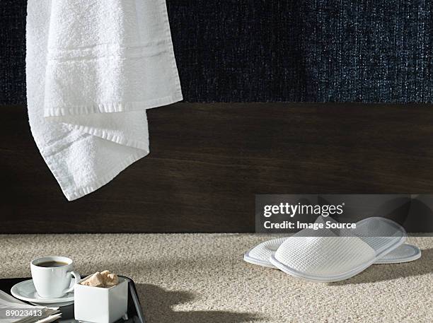 slippers and a towel in a hotel room - pantoffel stockfoto's en -beelden