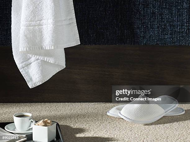 slippers and a towel in a hotel room - chinelos imagens e fotografias de stock