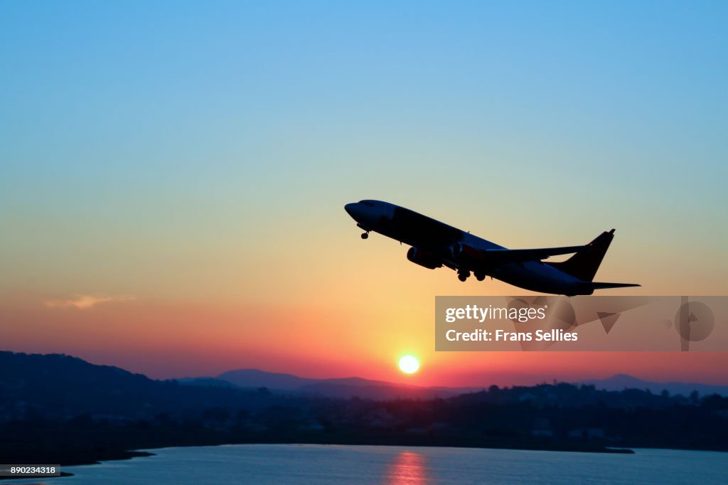 Silhouette of an airplane just after take off during sunset