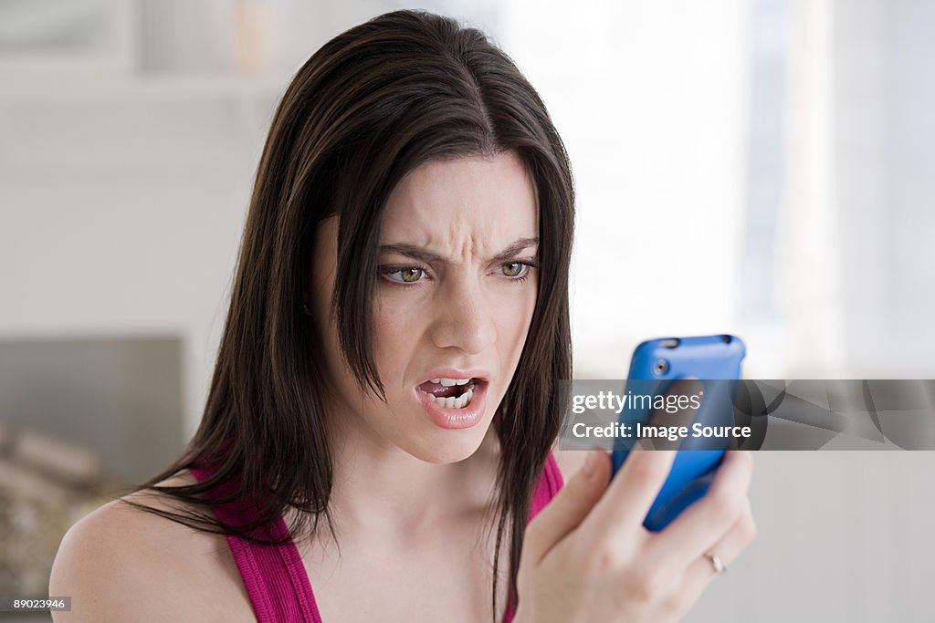 Angry woman looking at cellphone