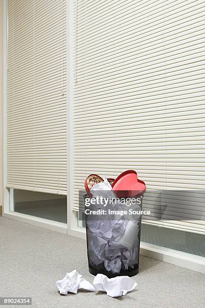 office wastepaper basket full of paper and discarded valentines chocolate box - waste basket stock pictures, royalty-free photos & images