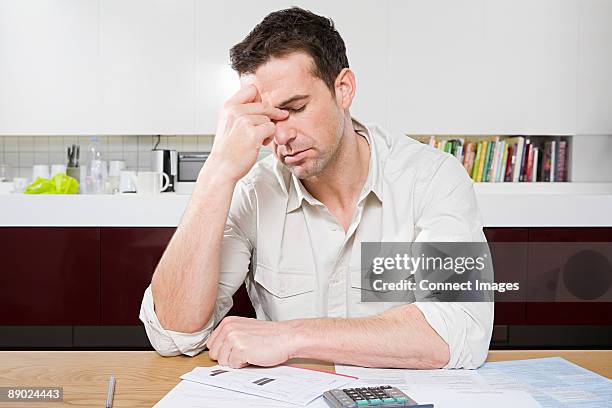 stressed man with bills - home finances man stock pictures, royalty-free photos & images