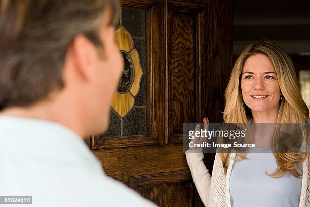 woman opening door - answering stock-fotos und bilder