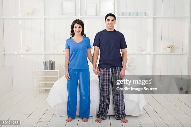 couple holding hands in a bedroom - pajamas stock pictures, royalty-free photos & images