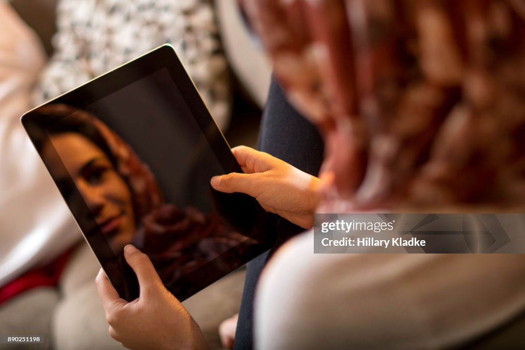 Muslim woman uses tablet as mirror