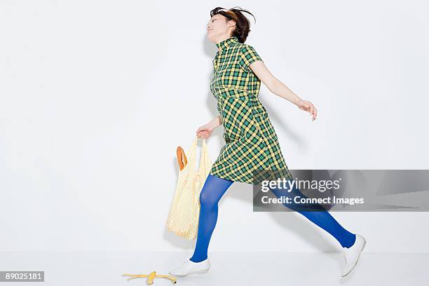 woman about to slip on banana skin - horizontal falls stock pictures, royalty-free photos & images