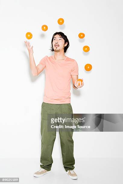 man juggling oranges - jonglieren stock-fotos und bilder