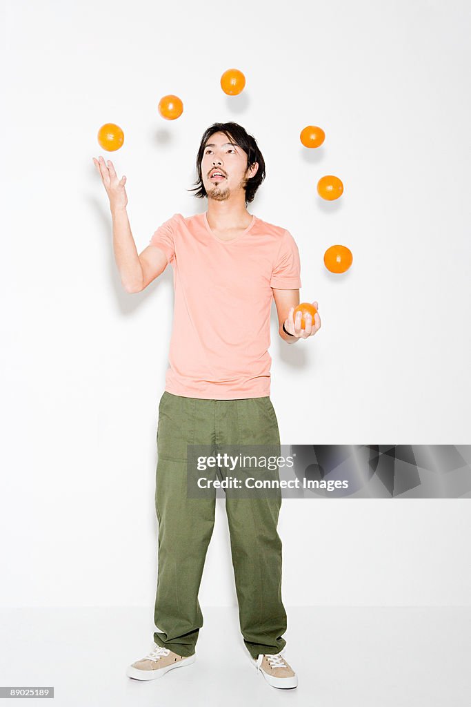 Man juggling oranges