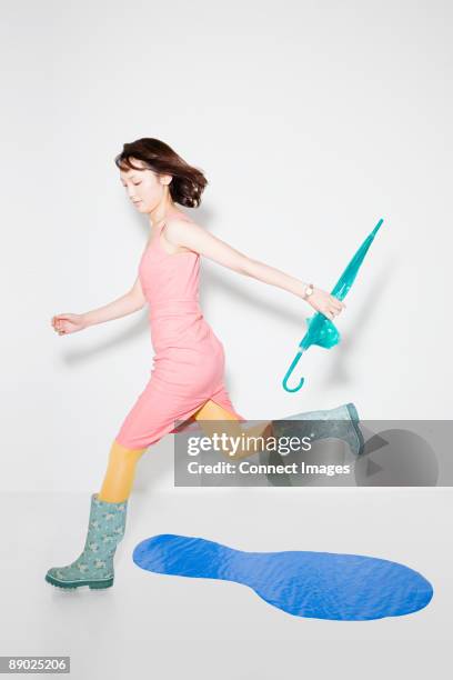 woman jumping over puddle - collant description physique photos et images de collection