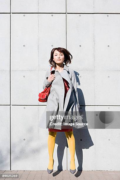young woman jumping - yellow purse foto e immagini stock