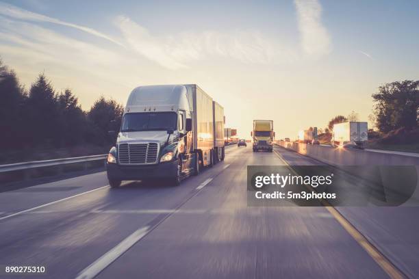 semi truck 18 wheeler sunrise on highway - eld stockfoto's en -beelden