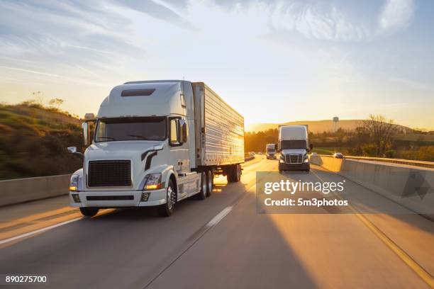 semi truck 18 wheeler sunrise on highway - truck highway stock-fotos und bilder