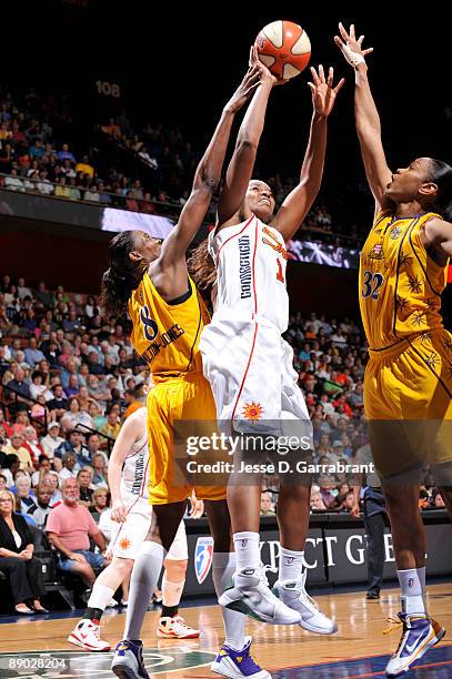 Asjha Jones of the Connecticut Sun shoots against DeLisha Milton-Jones and Tina Thompson of the Los Angeles Sparks during the WNBA game on July 14,...