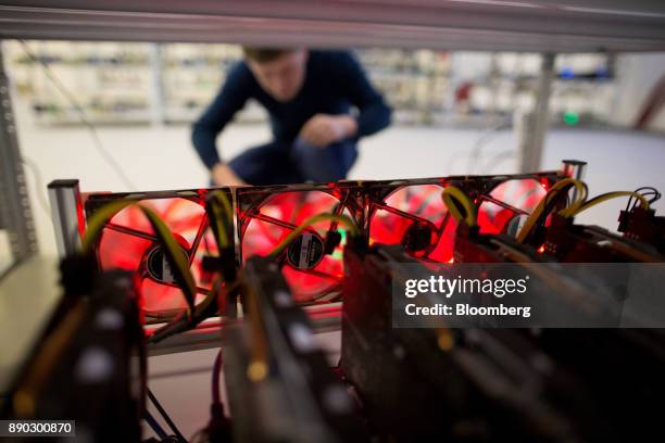 An employee checks cooling fans connecting a cryptocurrency mining rig at the SberBit mining 'hotel' in Moscow, Russia, on Saturday, Dec. 9, 2017....