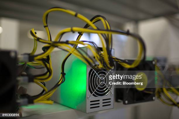 Power supply units and cooling fans sit on shelves linked to cryptocurrency mining machines at the SberBit mining 'hotel' in Moscow, Russia, on...