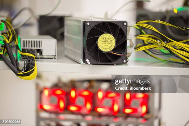 Power supply units and illuminated cooling fans sit on shelves linked to cryptocurrency mining machines at the SberBit mining 'hotel' in Moscow,...