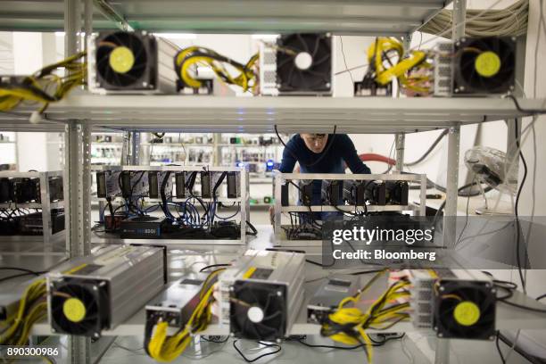 An employee checks power supply units and cooling fans linked to cryptocurrency mining machines at the SberBit mining 'hotel' in Moscow, Russia, on...