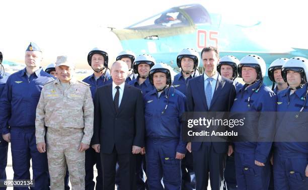 Russian President Vladimir Putin and President of Syria Bashar Al-Assad pose for a photo with pilots at Khmeimim Air Base in Latakia, Syria on...