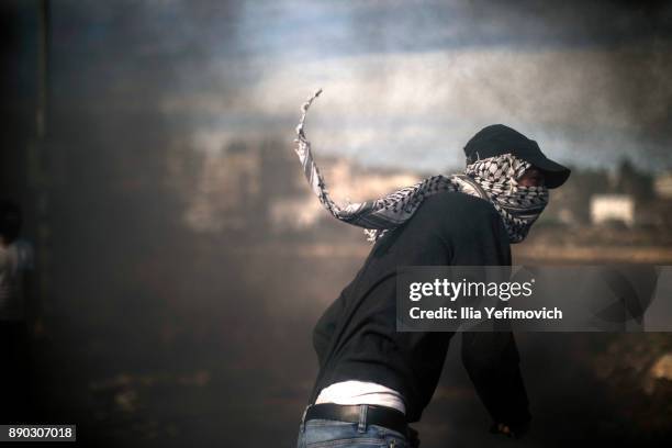 Palestinian youth throws rocks at Israeli Defence Forces in the streets on December 11, 2017 in North of Ramallah, West-Bank. Protest continues into...