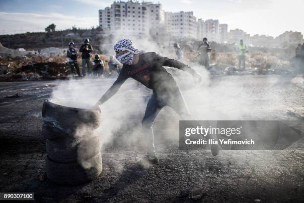 Palestinian youth light tires on fire as they clash with Israeli Defence Forces in the streets on December 11, 2017 in North of Ramallah, West-Bank....