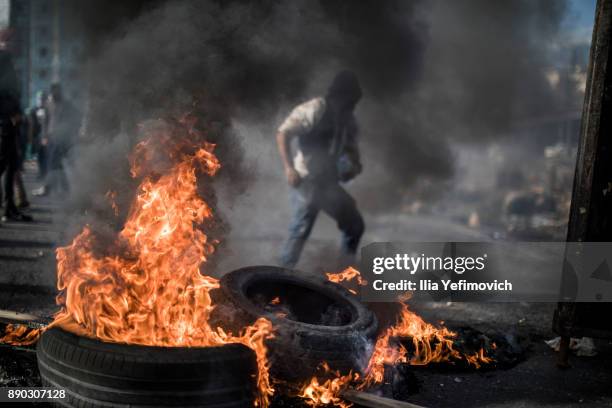 Palestinian youth light tires on fire as they clash with Israeli Defence Forces in the streets on December 11, 2017 in North of Ramallah, West-Bank....