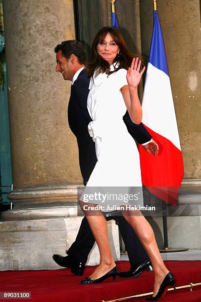 French President Nicolas Sarkozy and his wife Carla Bruni-Sarkozy arrive at a garden party to celebrate Bastille Day at Elysee Palace on July 14,...