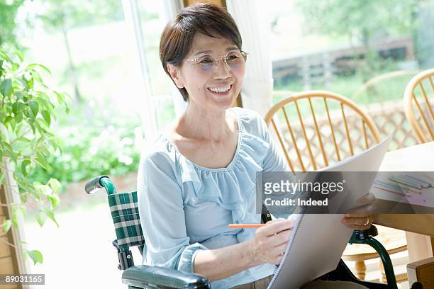 woman in wheelchair drawing on sketchbook - arts express yourself 2009 stock pictures, royalty-free photos & images