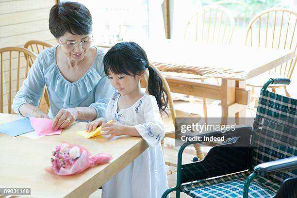 grandmother and granddaughter making origami - origami asia stock pictures, royalty-free photos & images