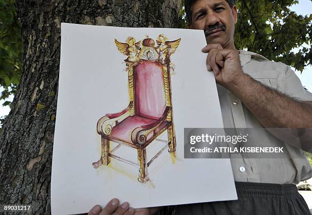 Un menuisier-sculpteur hongrois peaufine un siège doré pour le Saint-Père Master carpenter Arpad Rostas poses with a plan of a gold throne for the...