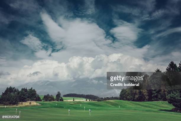 golf course with mountains covered by clouds on background - golf tournament stock pictures, royalty-free photos & images