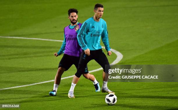 Real Madrid's Portuguese forward Cristiano Ronaldo vies for the ball against his Spanish midfielder teammate Isco during a training session two days...