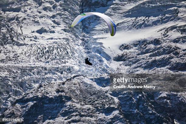 paragliding at high altitude in the chamonix valley with glacier ice and snow visible in the background. mont blanc mastiff, french alps - french mastiff stock pictures, royalty-free photos & images