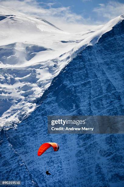 paragliding at high altitude in the chamonix valley with a steep mountain face visible in the background. mont blanc mastiff, french alps - french mastiff stock pictures, royalty-free photos & images