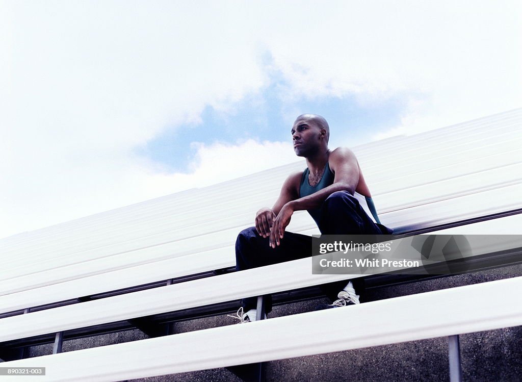 Athlete sitting in empty bleachers, low angle view