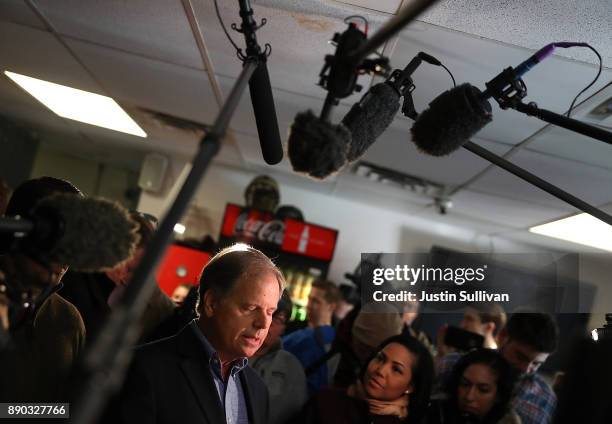 Democratic Senatorial candidate Doug Jones talks with reporters during a campaign stop at restaurant Chris Z's on December 11, 2017 in Birmingham,...