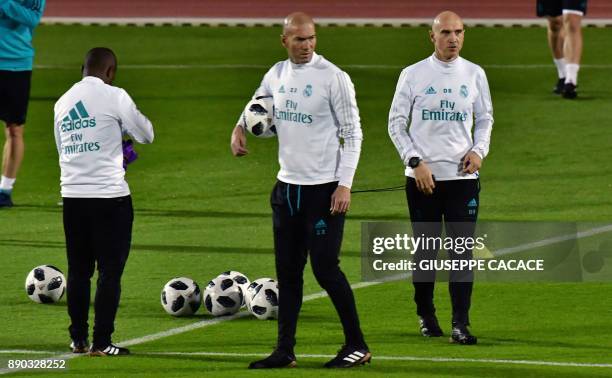 Real Madrid's French coach Zinedine Zidane and his French assistant David Bettoni stand on the pitch during a training session two days prior to...