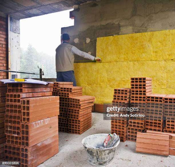 construction worker installing insulation in cavity wall. - cavity wall insulation stock pictures, royalty-free photos & images