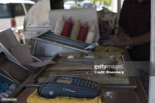 Credit card reader sits on the counter of a hot dog stand in the Chacao district of Caracas, Venezuela, on Wednesday, Dec. 6, 2017. Venezuelan...
